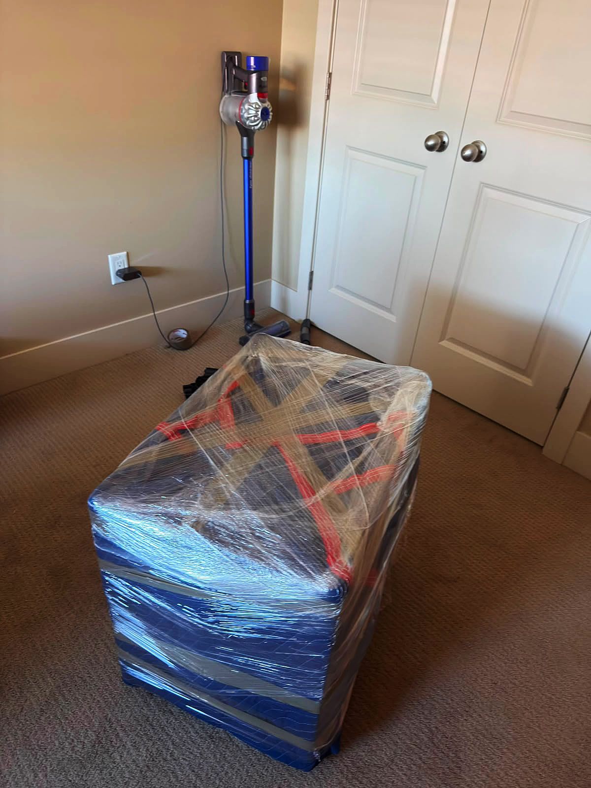 Dresser wrapped in blue moving blankets, taped and strapped for transport