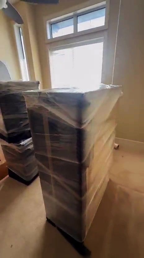 Furniture stretch-wrapped and padded, ready to load for a move.